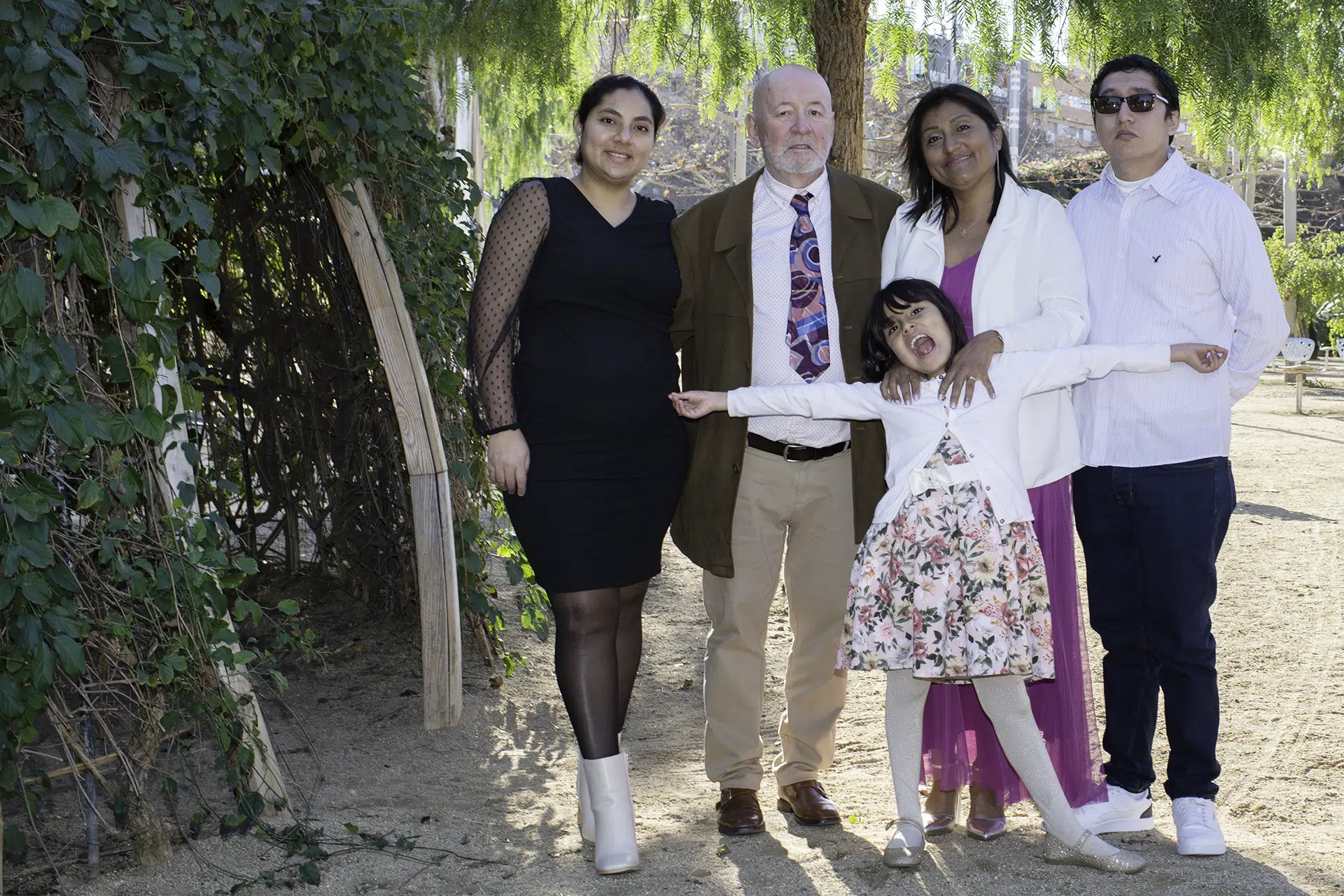 Entre sonrisas y abrazos, el amor de los recién casados se mezcla con la complicidad familiar… mientras la pequeña Ashley, traviesa, celebra la ocasión con brazos abiertos y entusiasmo desbordante, recordándonos que la alegría más auténtica no se puede contener