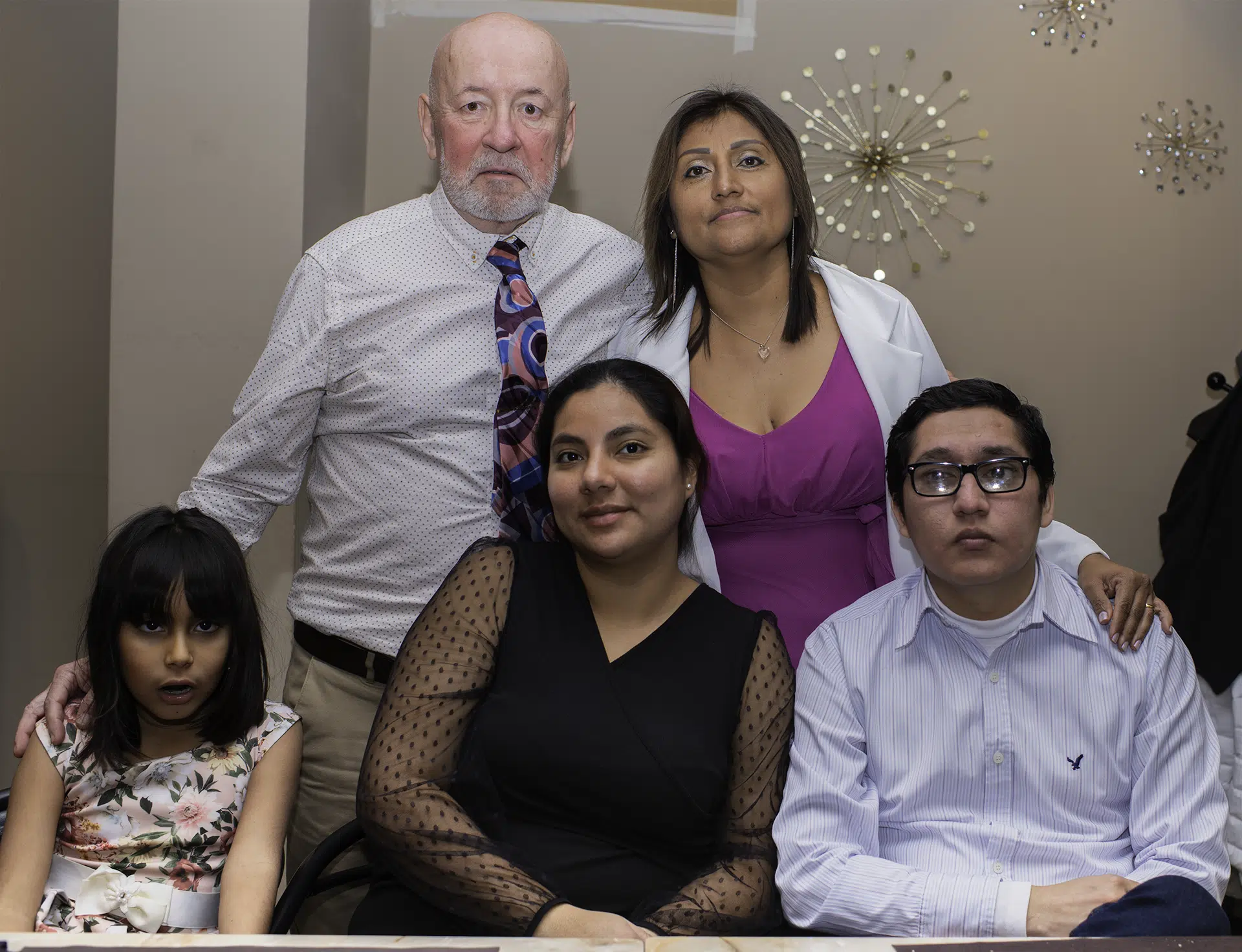 Zoila y Carlos posan junto a la familia de Zoila, sonrisas y miradas que celebran la unión de corazones y lazos que se fortalecen.