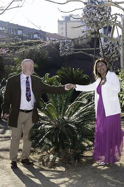 A través de este gesto, no solo se tocan las manos, sino también los corazones. Carlos observa a Zoila con mirada profunda, mientras Zoila, mirando hacia el futuro, sostiene la promesa de un amor que supera cualquier distancia.