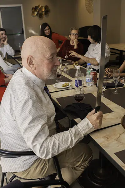 Carlos observando fijamente el cuchillo de pastel que tiene en mano